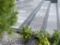 Nowoczesne aranżacje kostka brukowa wzory: szare płyty i obrzeża tworzą eleganckie schody, otoczone zielenią.