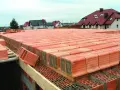 Budowa stropu ackermana z pustaków ceramicznych. Widać rzędy pustaków przygotowanych do ułożenia.
