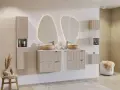 Nowoczesna łazienka z podwójną umywalką i szafkami z ryflowanymi frontami. Oświetlone lustra dodają elegancji.