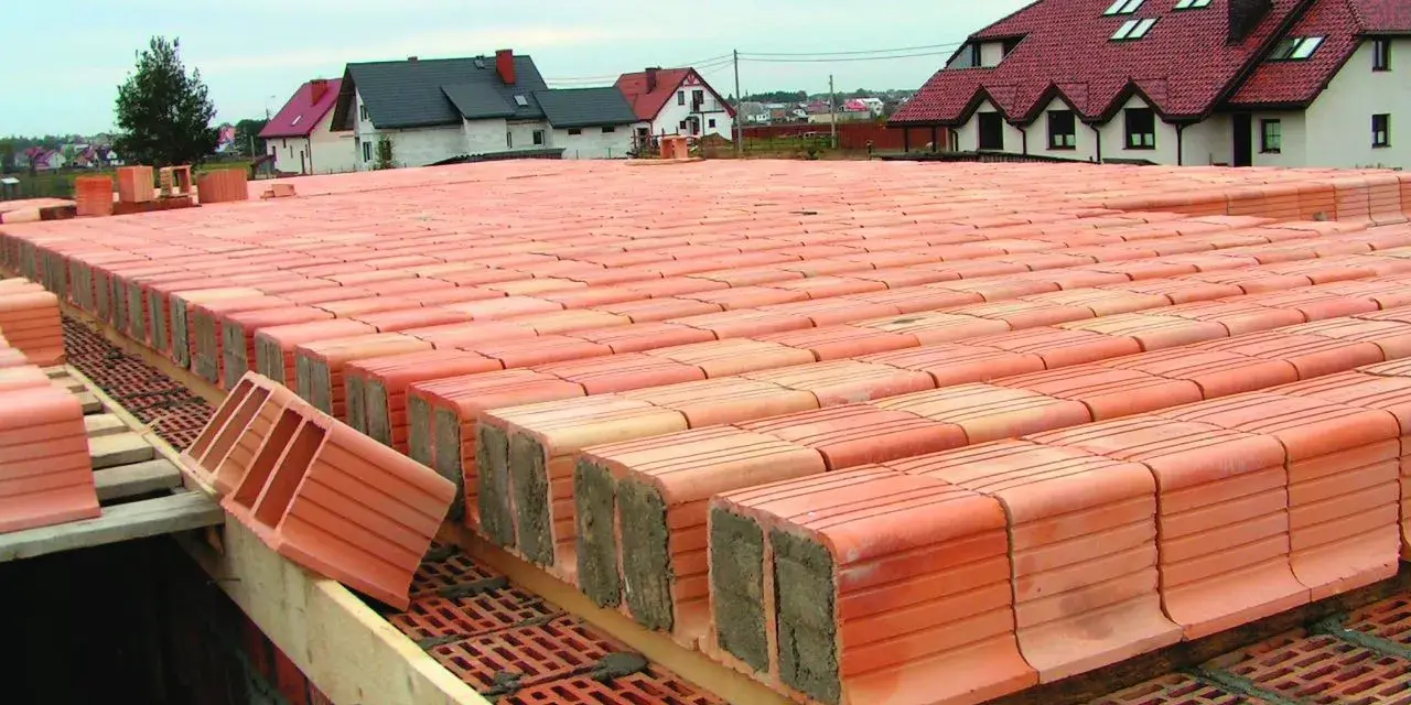 Budowa stropu ackermana z pustaków ceramicznych. Widać rzędy pustaków przygotowanych do ułożenia.