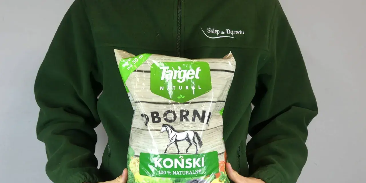 Osoba w zielonej bluzie trzyma worek z napisem "OBORNIK KOŃSKI GRANULOWANY". Idealny do ogrodu.