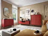 Nowoczesny salon z meblami w intensywnym, bordowym kolorze. Wygodna kanapa i stylowe komody tworzą przytulną przestrzeń.