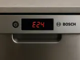 Wyświetlacz zmywarki Bosch pokazuje błąd E24. Czerwone cyfry E24 na czarnym tle obok przycisku zasilania.