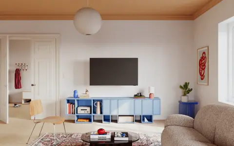 Salon z niebieską szafką RTV, drewnianym krzesłem i dywanem w orientalne wzory. Eklektyzm w czystej postaci.