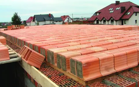 Budowa stropu ackermana z pustaków ceramicznych. Widać rzędy pustaków przygotowanych do ułożenia.