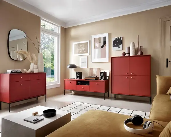 Nowoczesny salon z meblami w intensywnym, bordowym kolorze. Wygodna kanapa i stylowe komody tworzą przytulną przestrzeń.
