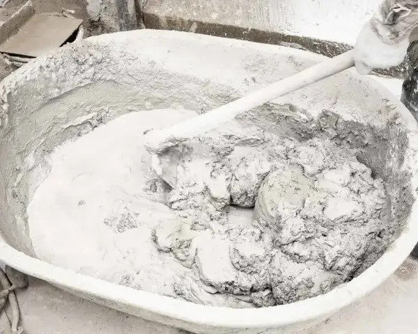 Mieszanie wapna gaszonego w dużej kadzi, tworząc gładką masę do prac budowlanych.