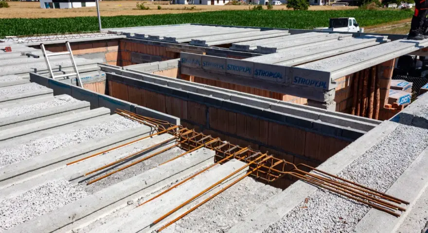 Budowa domu w toku. Widać prefabrykowane stropy Teriva, zbrojenie i pustaki. Dobra strop teriva cena to klucz do szybkiej budowy.