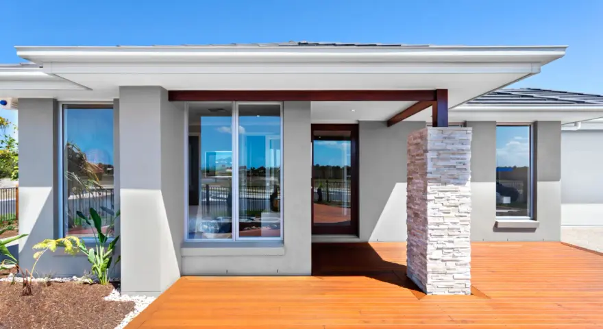 Nowoczesna elewacja w odcieniach szarości, z drewnianym tarasem i kamienną kolumną. To jedne z najmodniejszych kolorów elewacji.